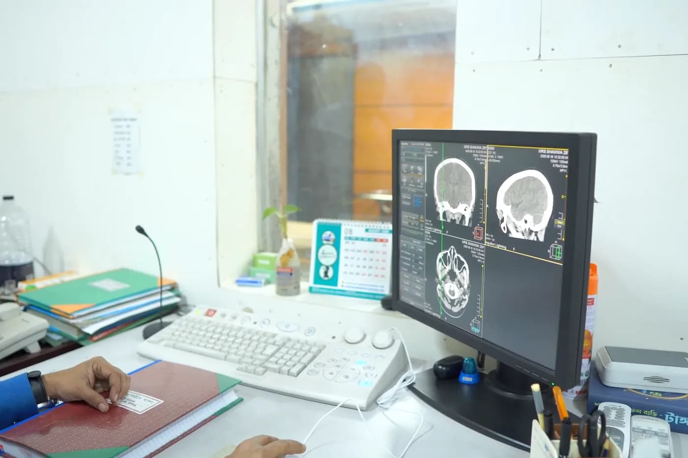 CT scan control room with brain scan images on the reporting console at Dhaka Clinic, Tangail