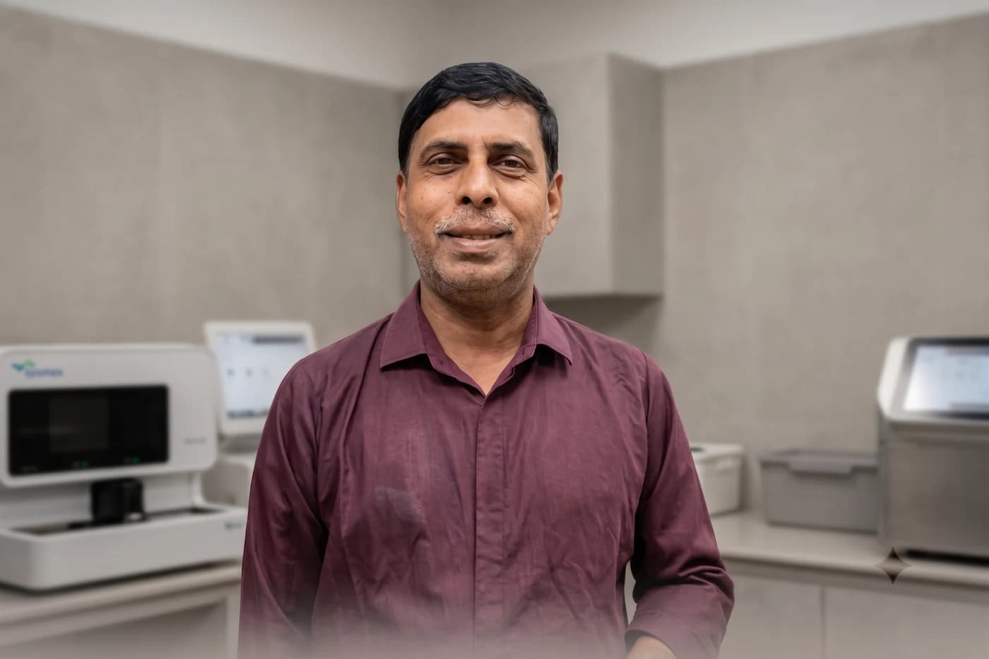 Md. Didar Hossain in the pathology laboratory at Dhaka Clinic & Nursing Home, Tangail, with the haematology analysers behind him