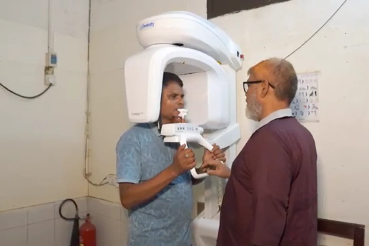 Patient positioned in the OPG panoramic dental X-ray machine at Dhaka Clinic, Tangail